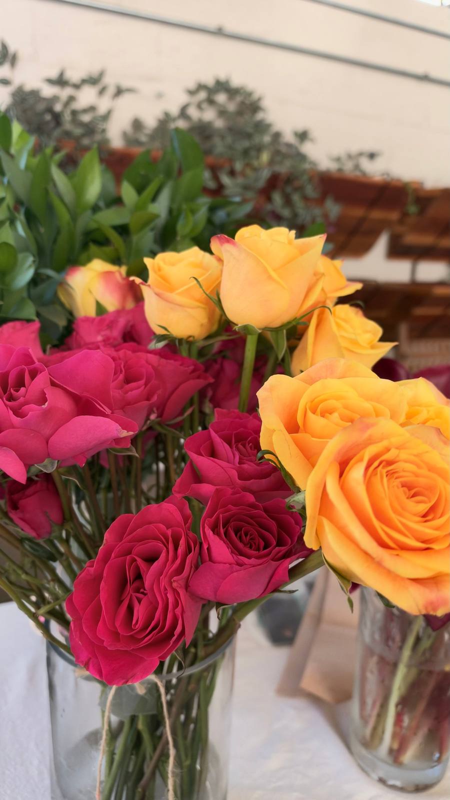 Hot pink and golden roses in glass vases