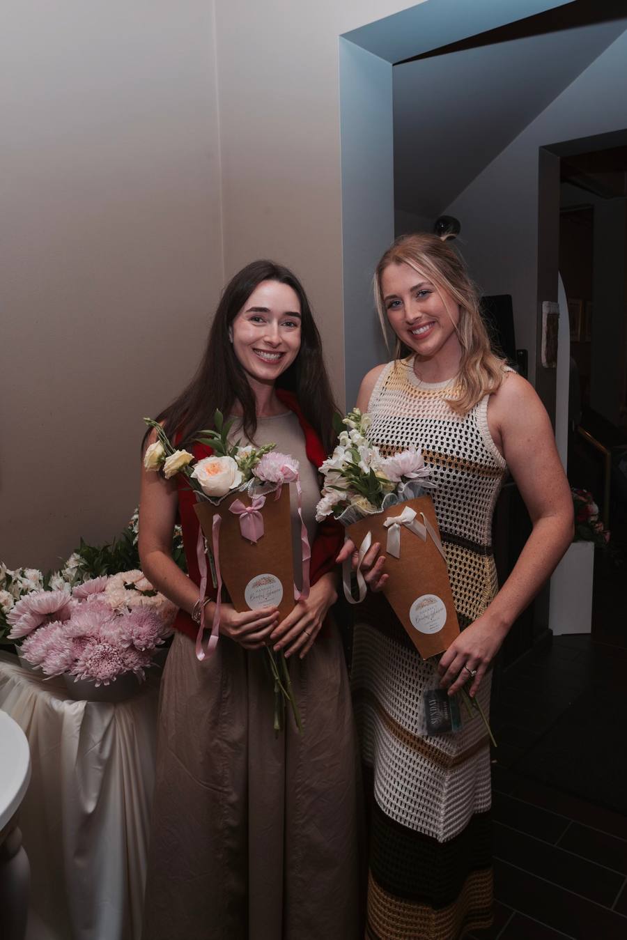 Two smiling guests holding the bouquets they built