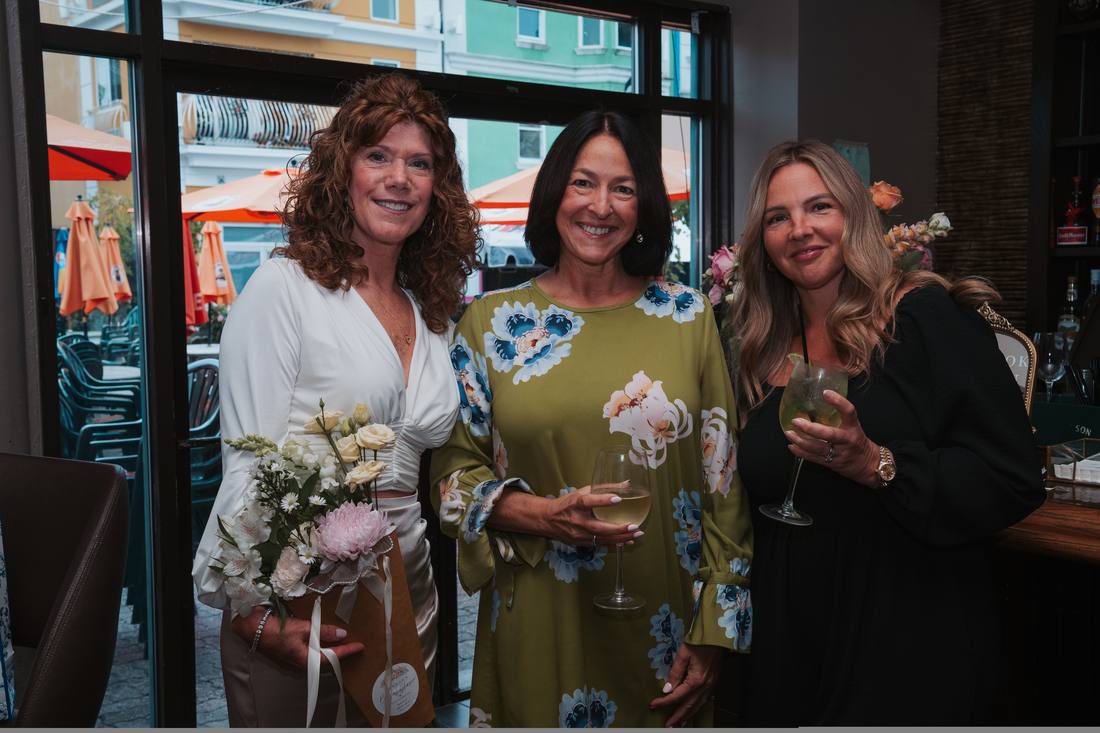Three guests showing off their finished bouquets